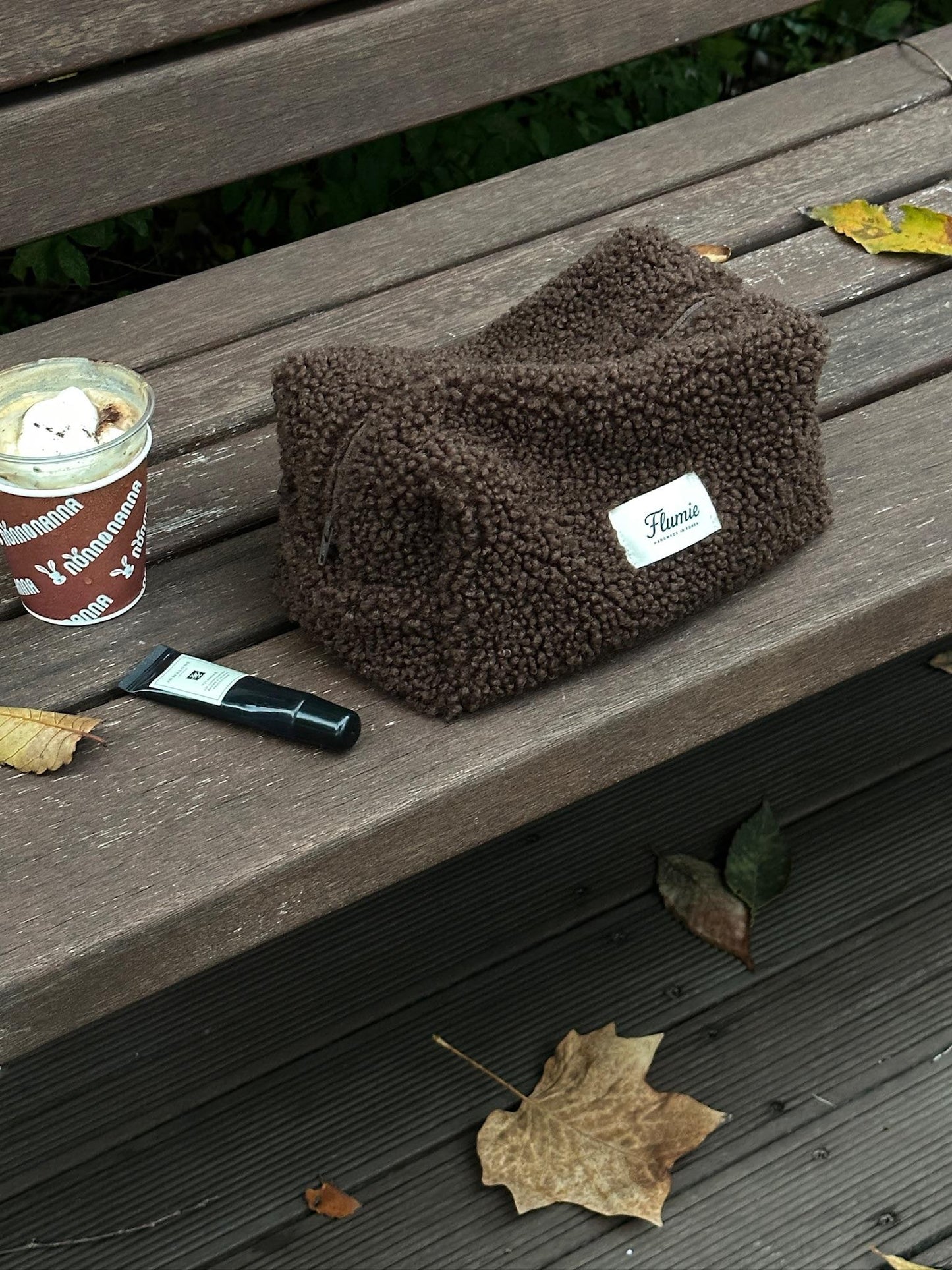 Brown fluffy pouch surrounded by autumn leaves and warm tones, perfect for a soft aesthetic routine