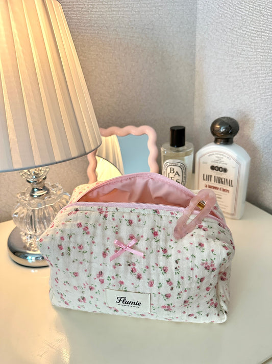 Rosymilk floral pouch on a vanity next to Diptyque perfume & soft lamp