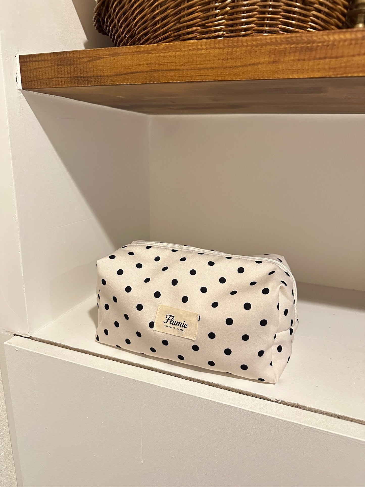 Natural light highlighting the texture of the ivory pouch with a timeless feel
