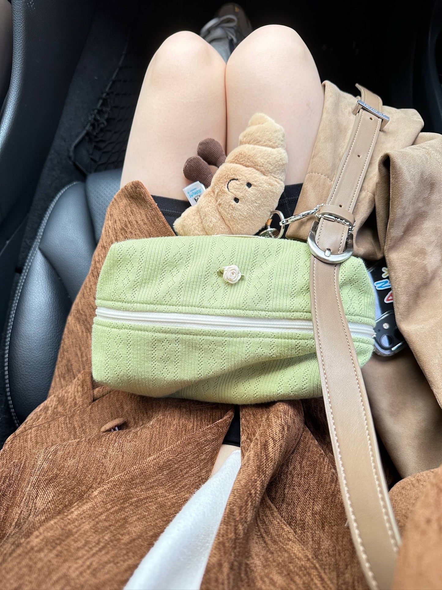 Flumie matcha pouch resting on a lap with plush toy and autumn tones, blending girly charm with everyday comfort