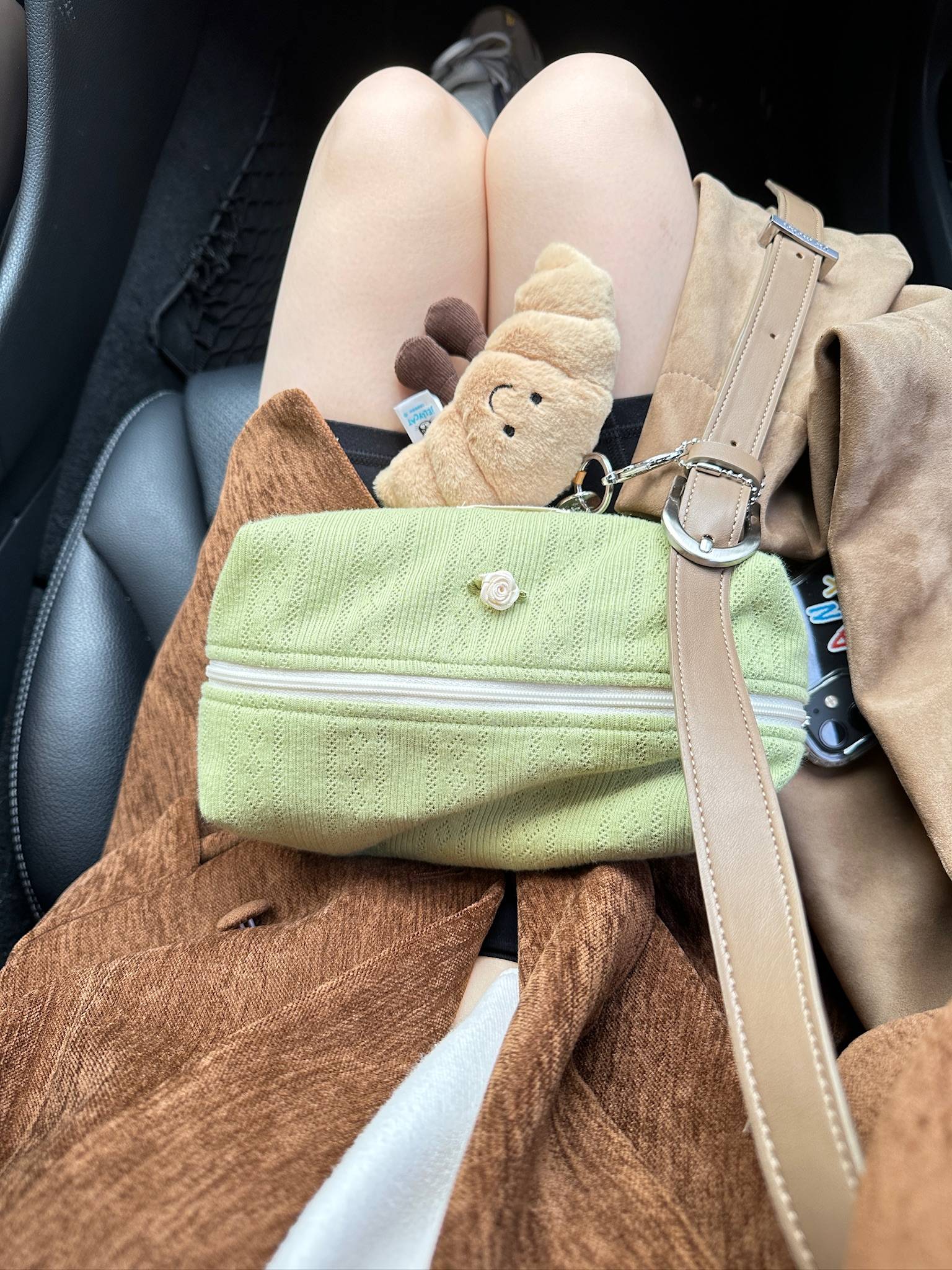 Flumie matcha pouch resting on a lap with plush toy and autumn tones, blending girly charm with everyday comfort