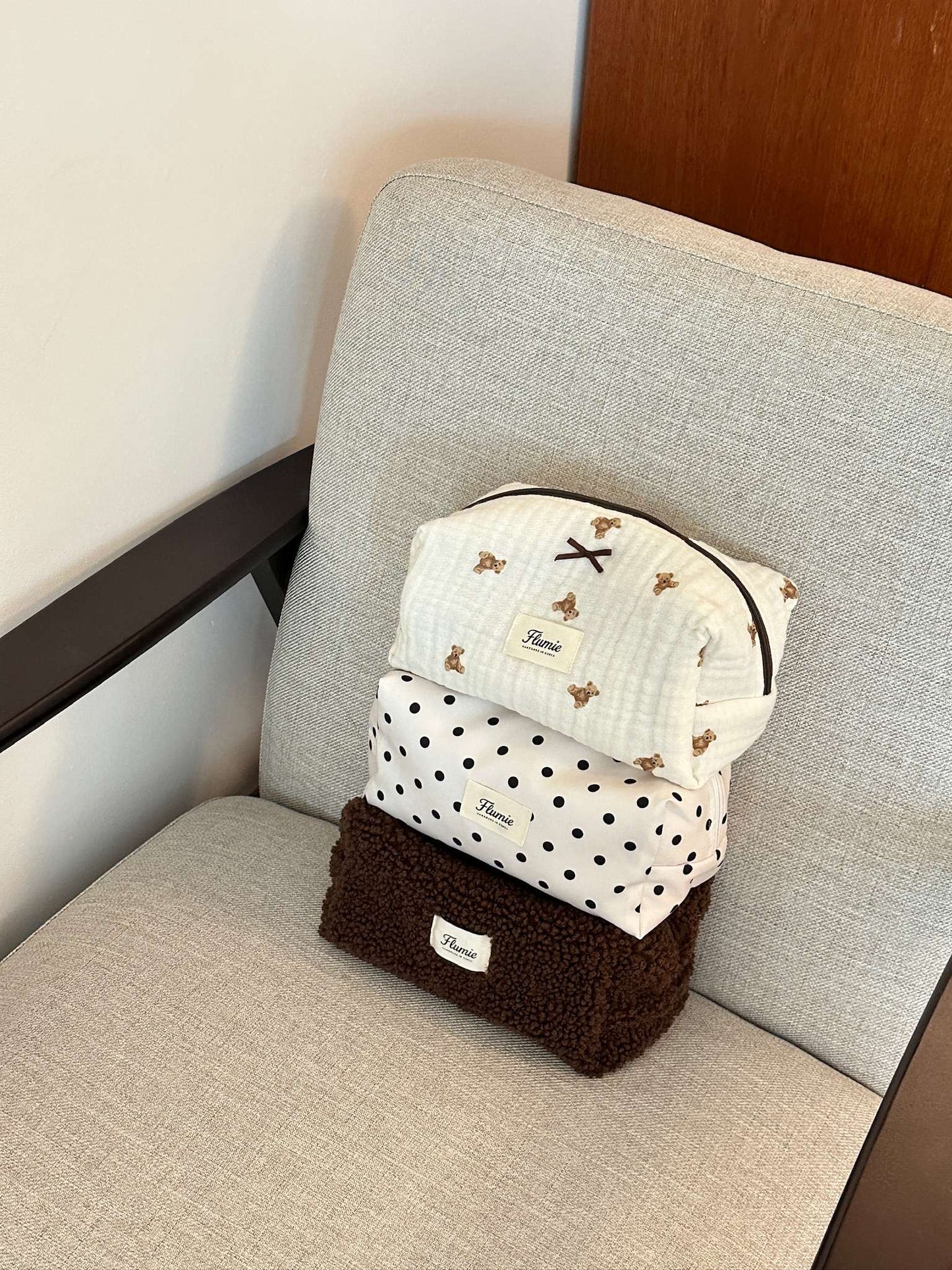 Ivory dot pouch styled with soft makeup items, offering a clean and girly mood