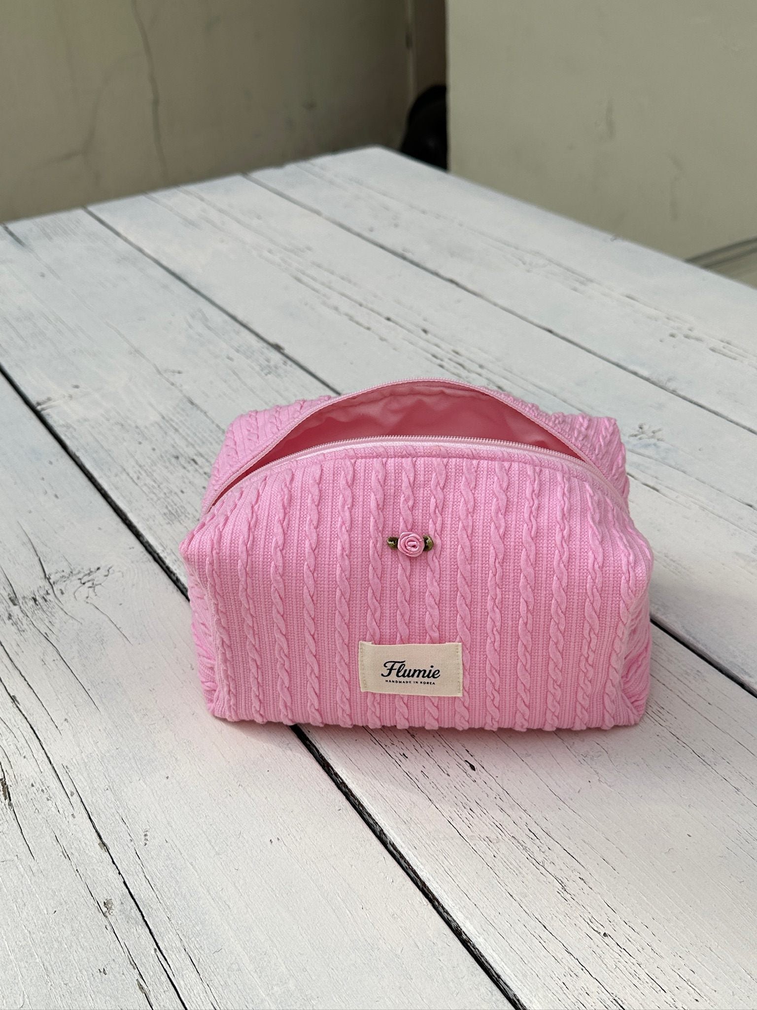 Rose accent on the cable knit texture adds a classic feminine point