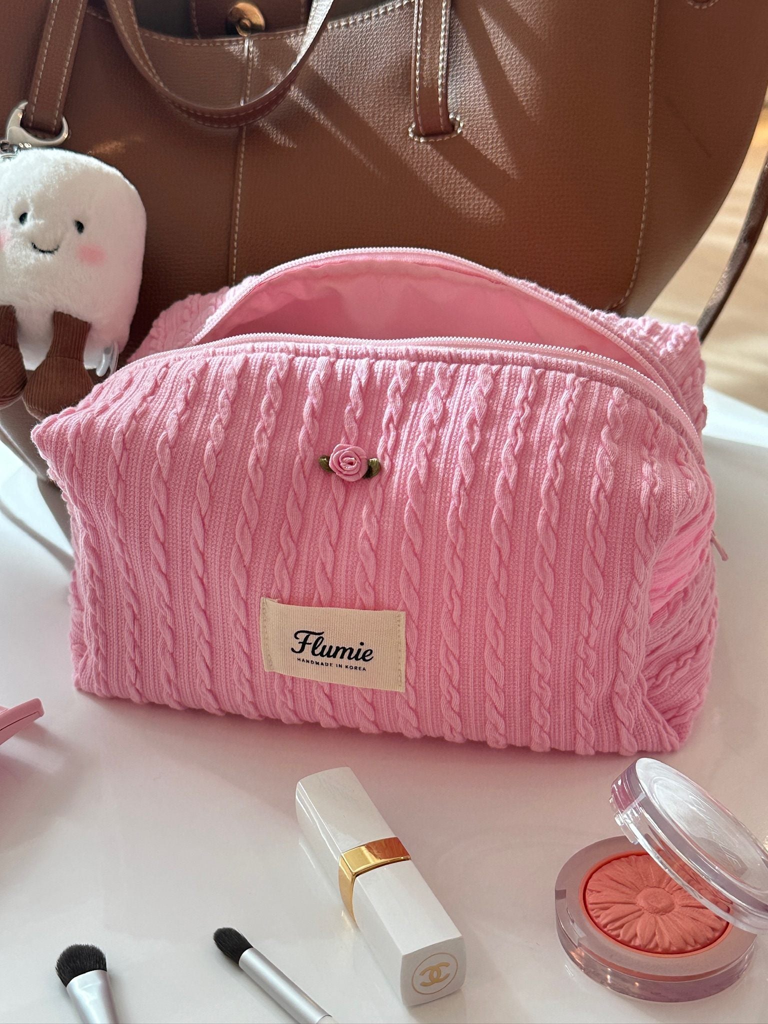 Girly pink pouch with lipstick and mirror, creating a daily clean girl beauty flatlay