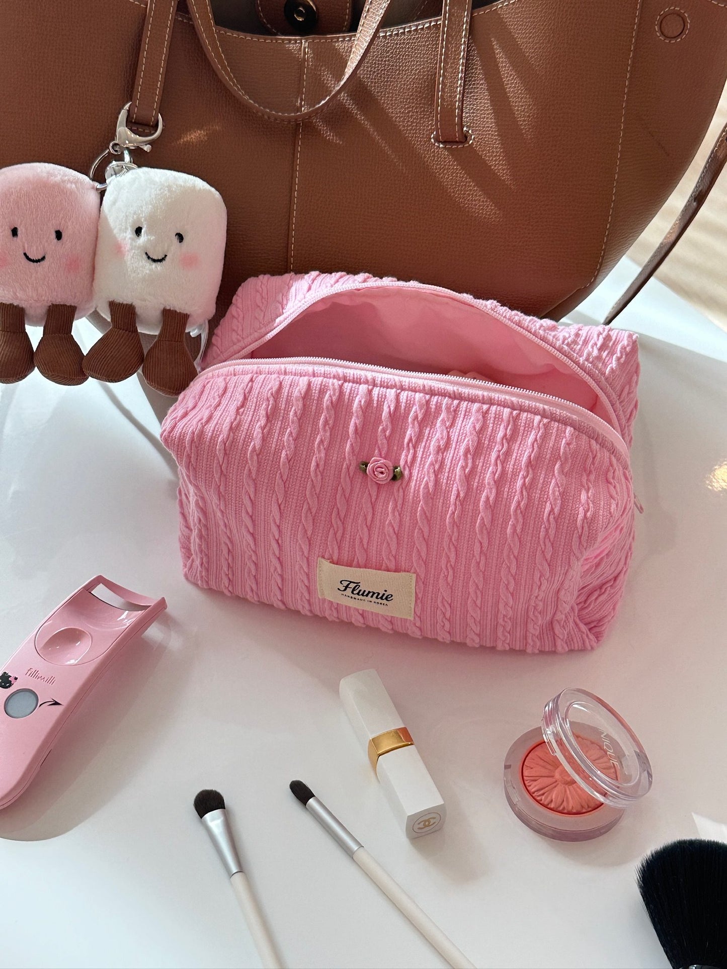 Girly pink pouch with lipstick and mirror, creating a daily clean girl beauty flatlay